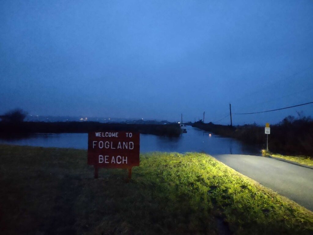 a sign on the side of a road next to a body of water (MyCoast AI)