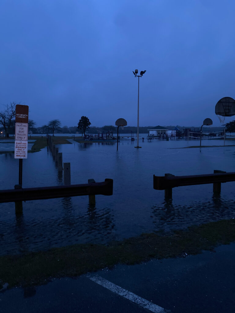 a flooded area with a bench and a sign (MyCoast AI)