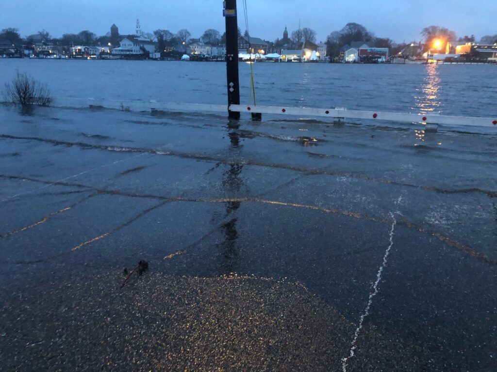 a wet road with a pole and a body of water in the background (MyCoast AI)