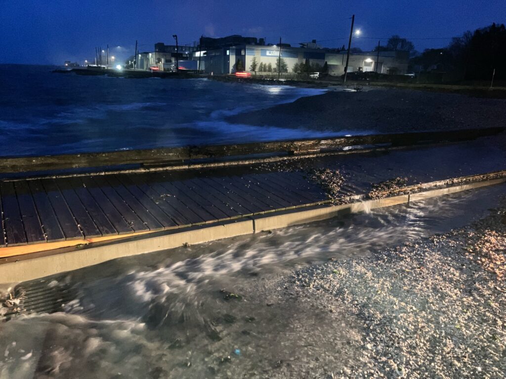 a dock with a boat in the water by a beach (MyCoast AI)