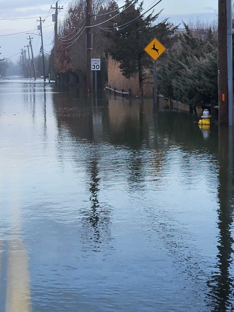 a flooded street with a yellow sign (MyCoast AI)