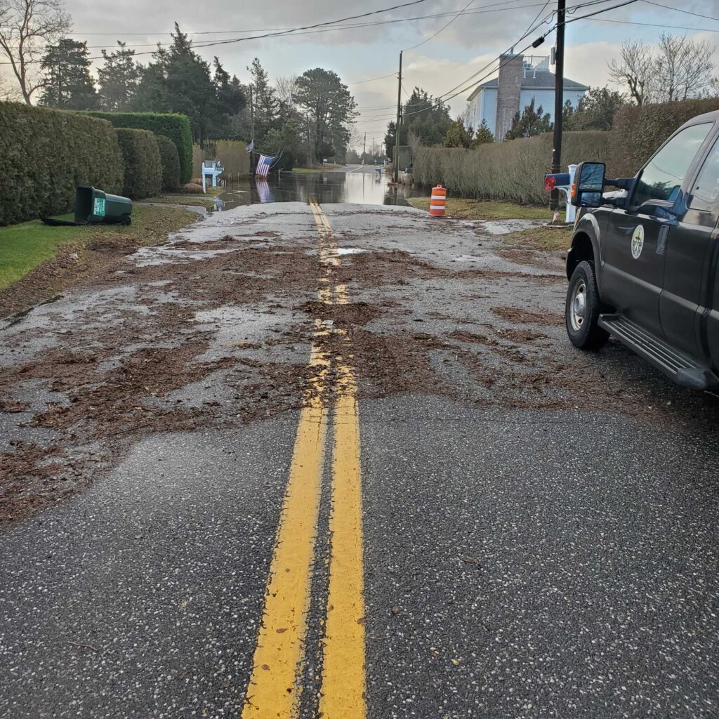 a car on a road with a puddle of water on the side (MyCoast AI)