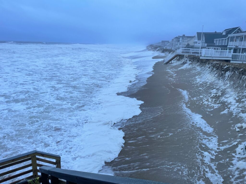 a beach with waves crashing against a pier (MyCoast AI)
