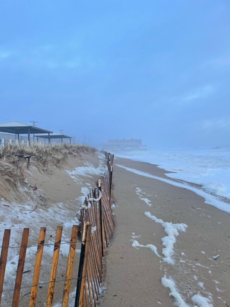 a beach with a fence and a building on the shore (MyCoast AI)