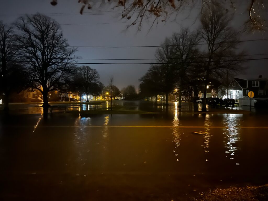 a wet street with trees and buildings (MyCoast AI)