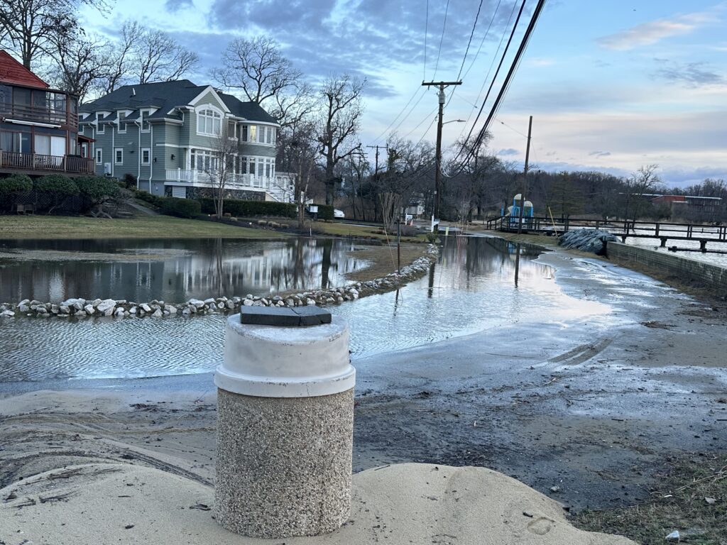 a concrete post in front of a body of water with houses in the background (MyCoast AI)