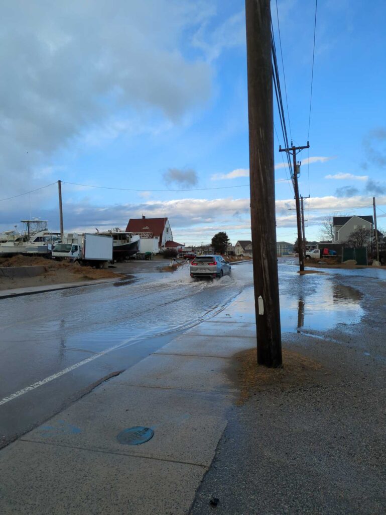 a flooded street with a truck and a car driving on it (MyCoast AI)