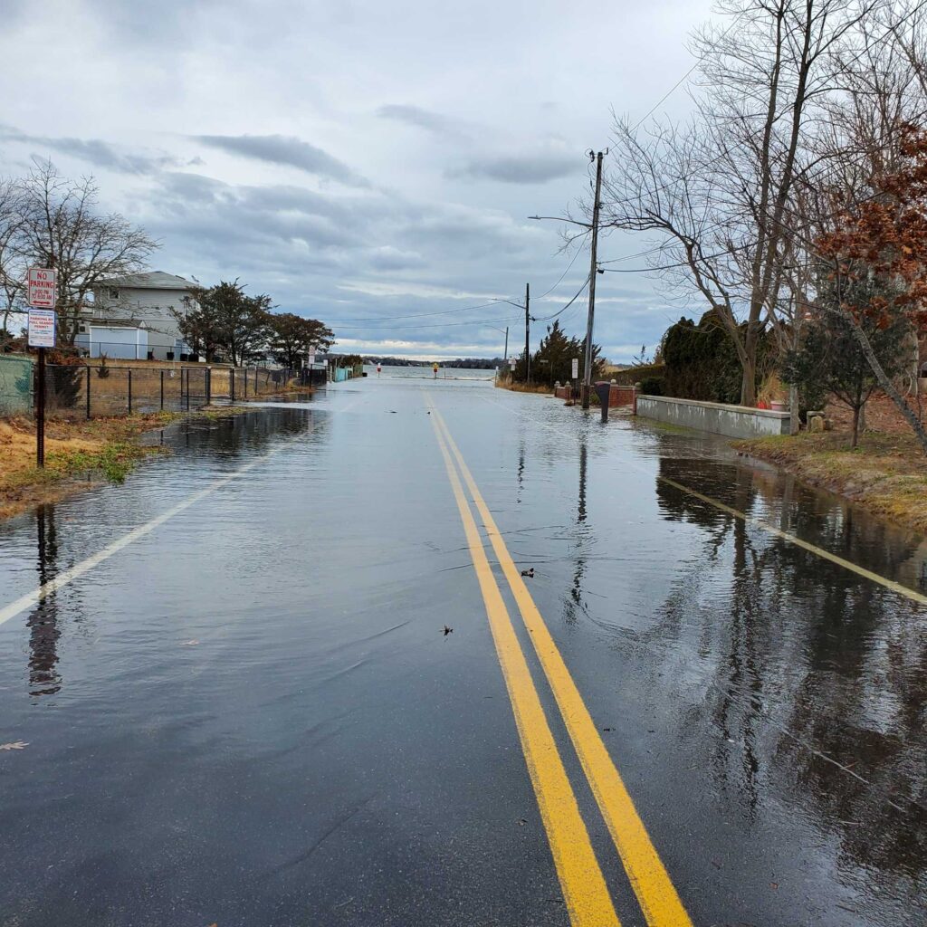 a wet road with a puddle on the side (MyCoast AI)