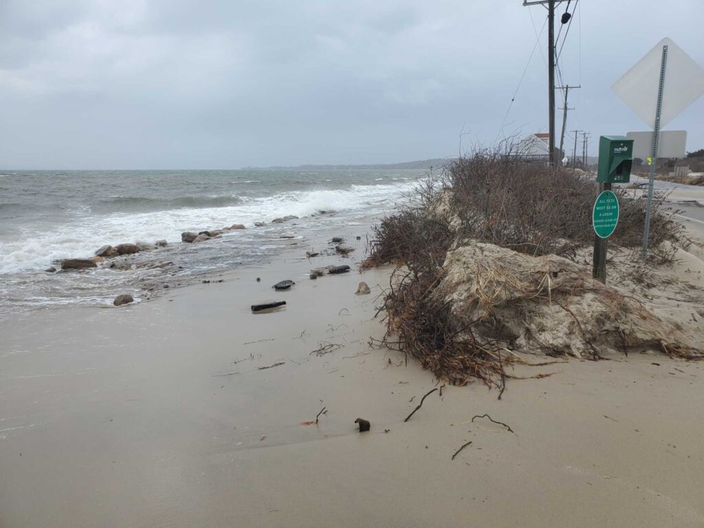 a beach with a sign and a pile of debris (MyCoast AI)
