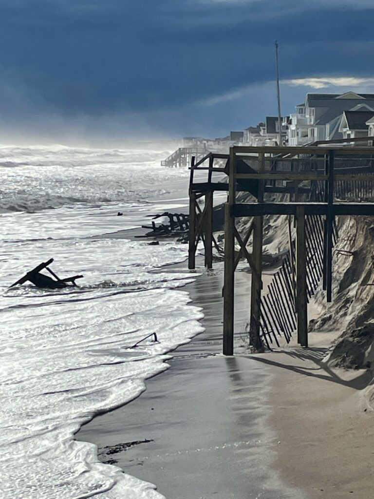 a beach with waves crashing against a pier (MyCoast AI)