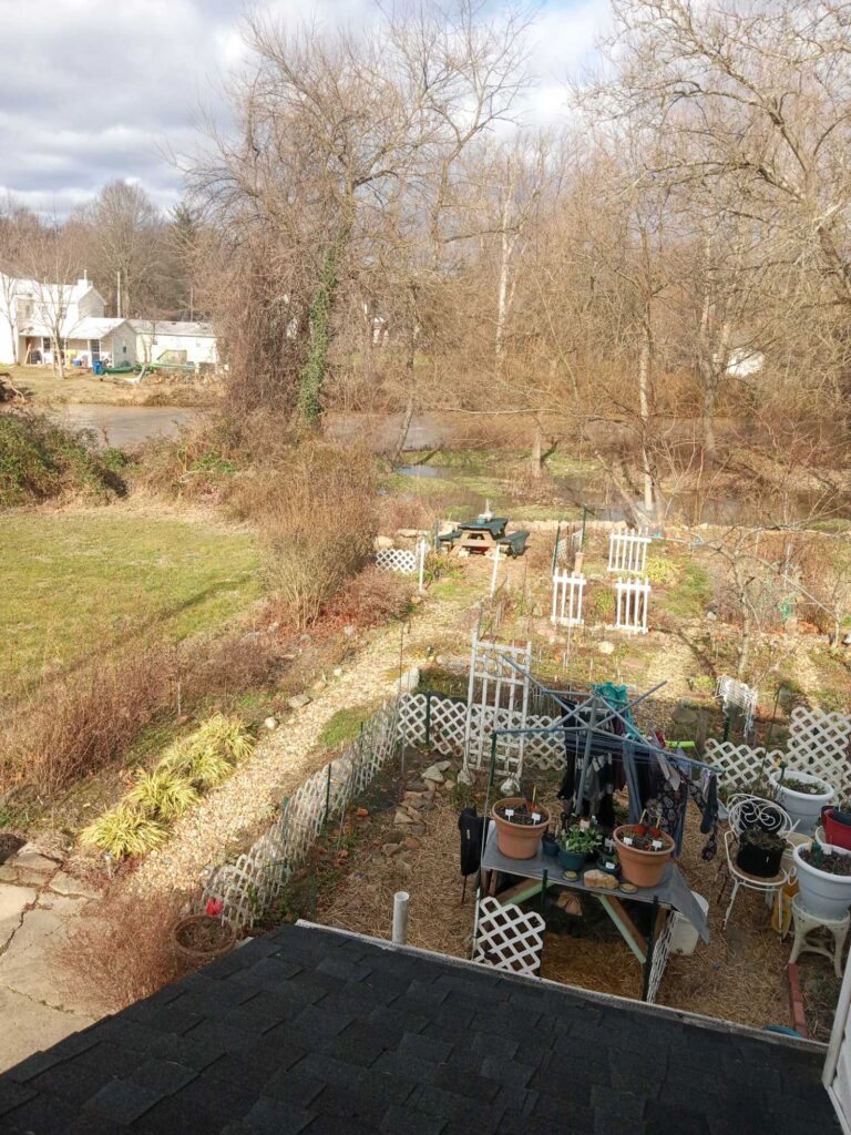 a backyard with a patio and a table and chairs and a yard with trees and houses (MyCoast AI)