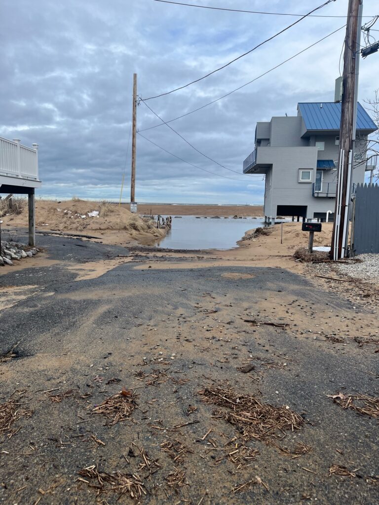 a dirt road with power lines on the side and a building in the background (MyCoast AI)
