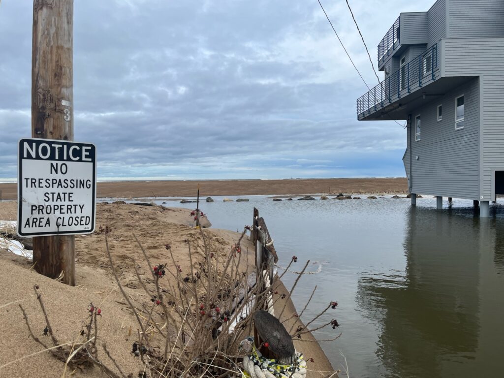 a sign on a pole next to a body of water (MyCoast AI)
