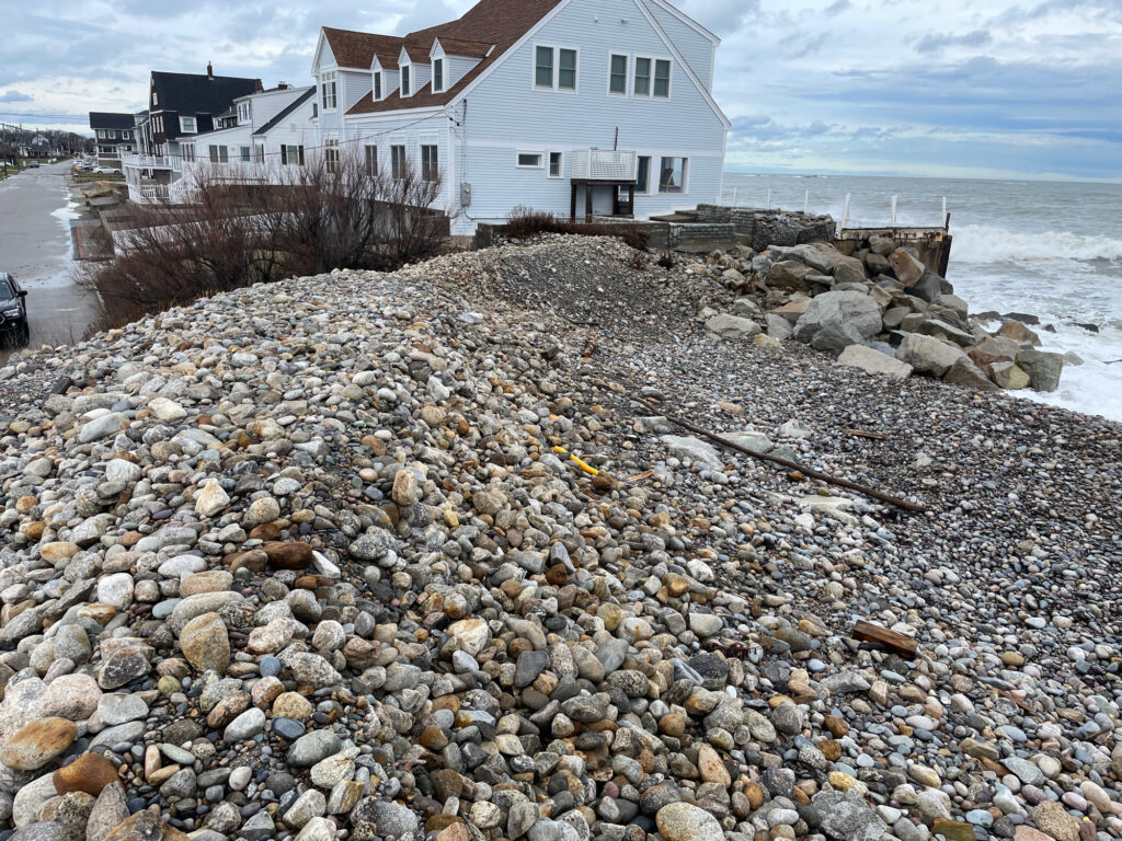a rocky beach with a house in the background (MyCoast AI)