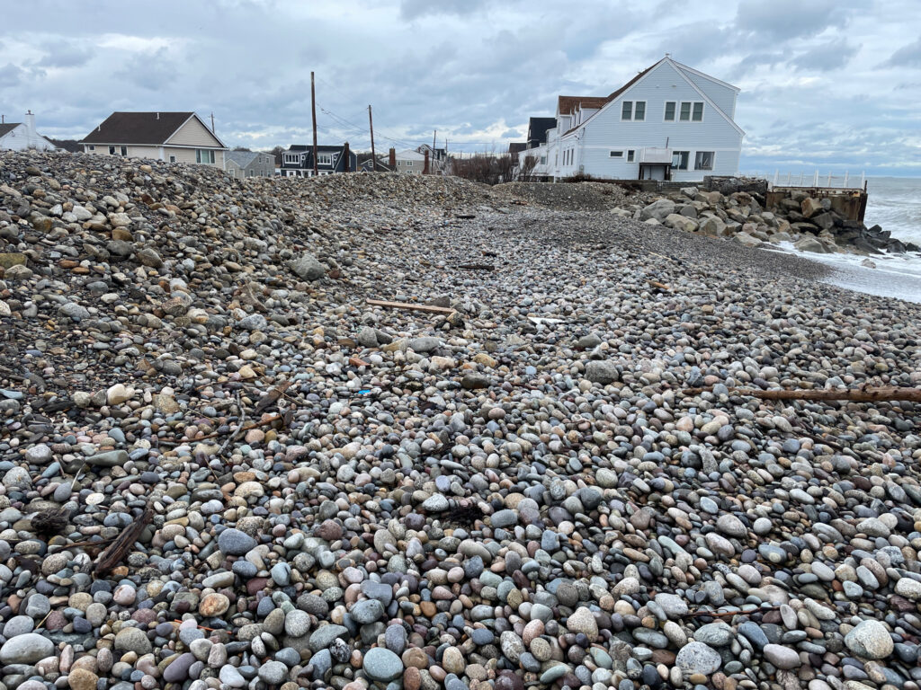 a rocky beach with houses in the background with Mount Arafat in the background (MyCoast AI)