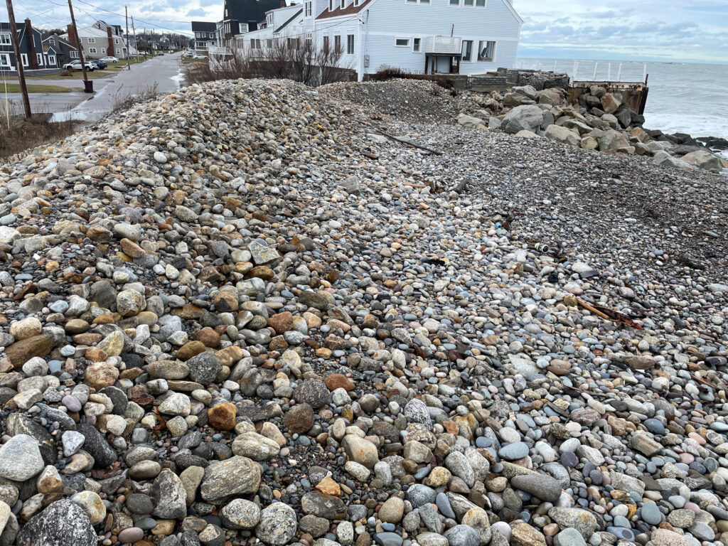 a rocky beach with a house in the background (MyCoast AI)