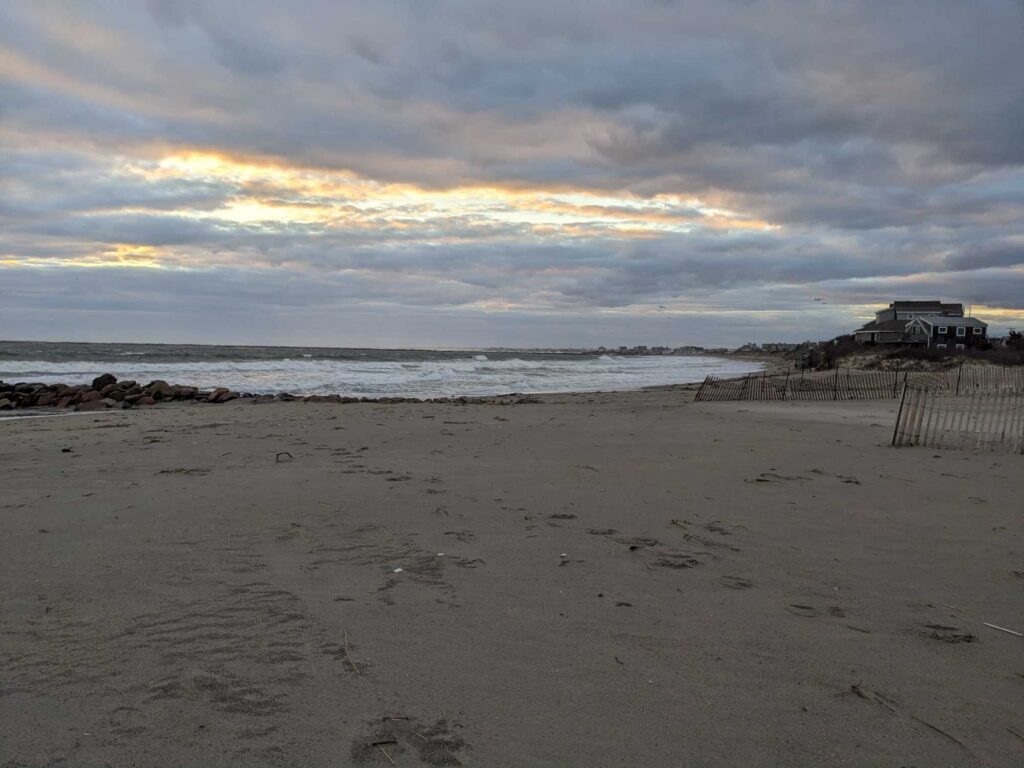 a beach with a fence and a building in the distance (MyCoast AI)