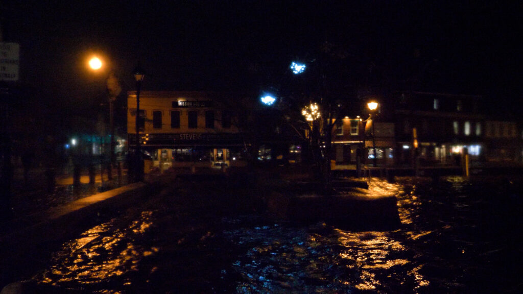 a street with buildings and lights at night (MyCoast AI)