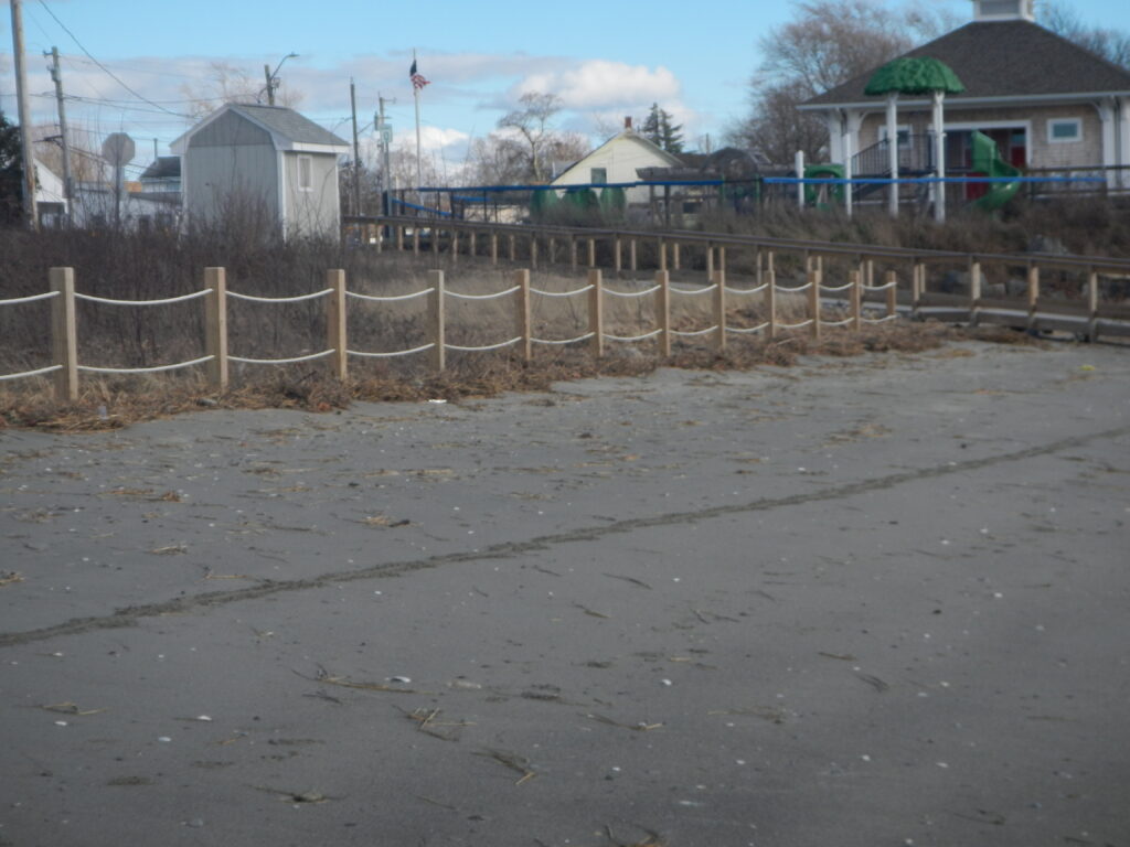 a fenced off area with a wooden fence and a building in the background (MyCoast AI)