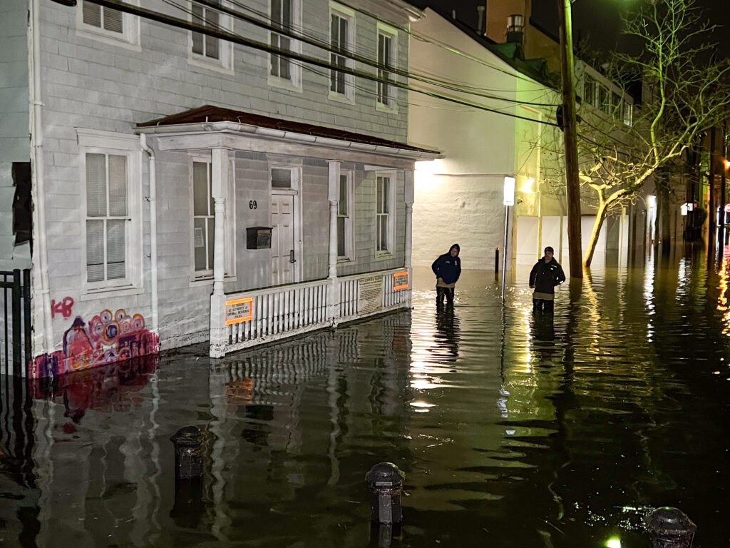 a couple people walking in a flooded street (MyCoast AI)