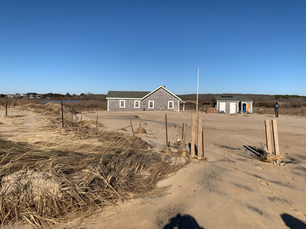 a dirt road with a fence and a house in the background (MyCoast AI)