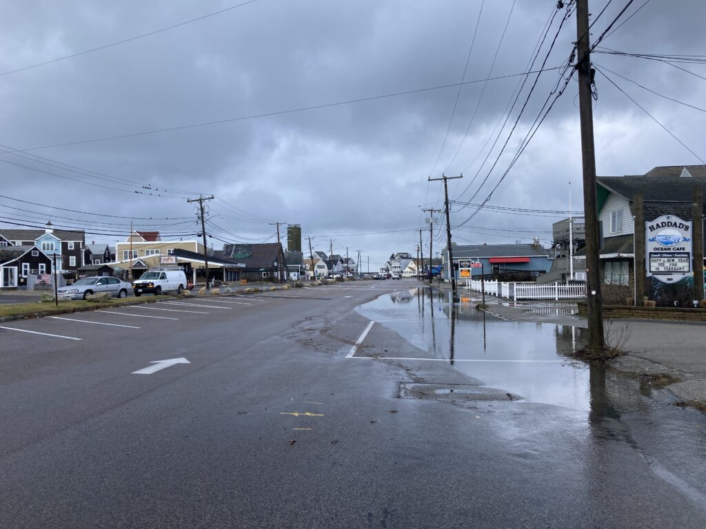 a wet street with buildings and cars (MyCoast AI)
