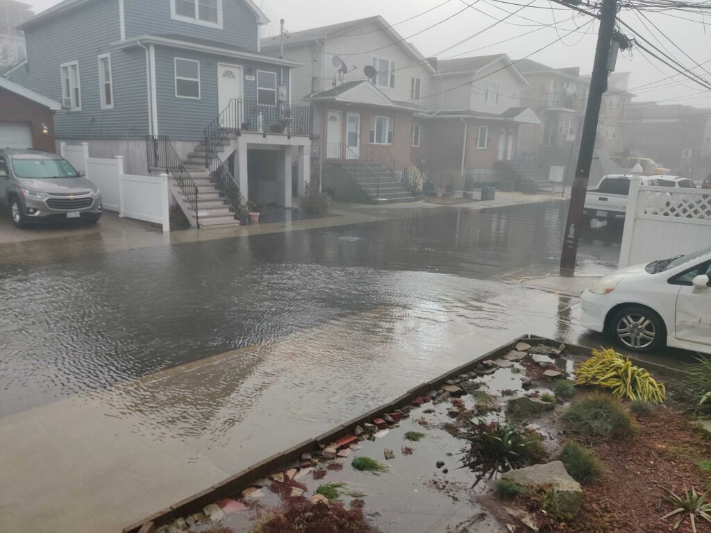 a flooded street with cars and houses (MyCoast AI)