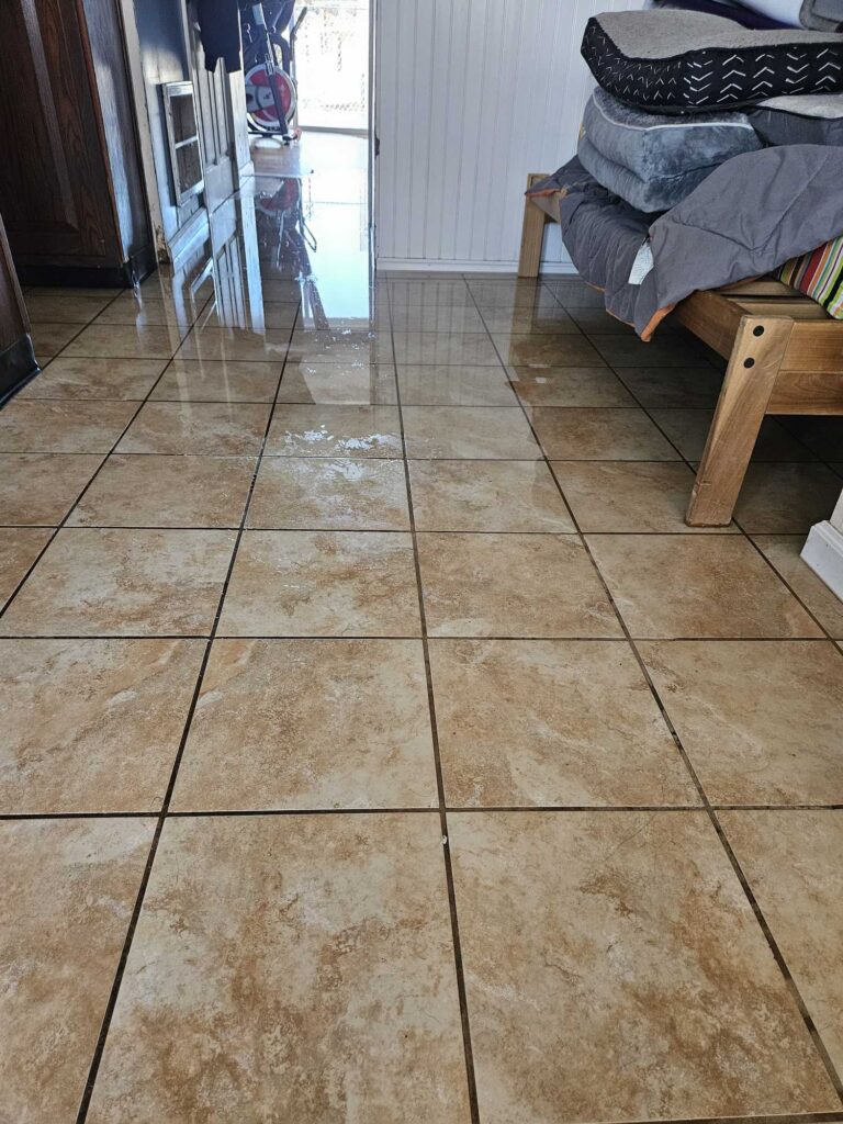 a room with a tile floor and a table with a chair and a door (MyCoast AI)