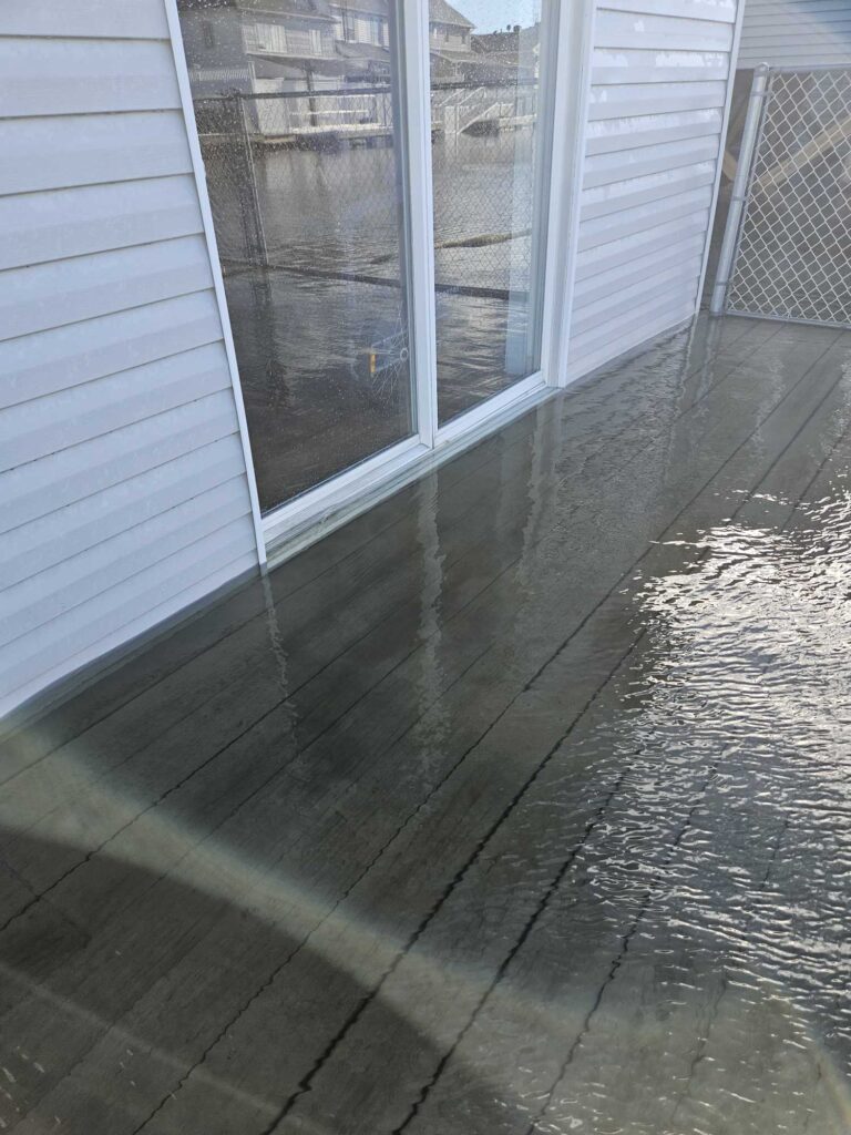 a wet patio with a metal fence (MyCoast AI)