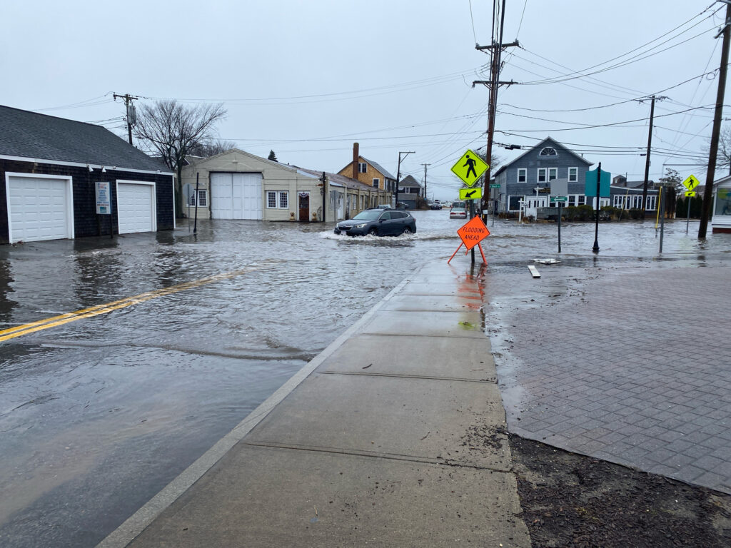 a flooded street with a car driving through it (MyCoast AI)