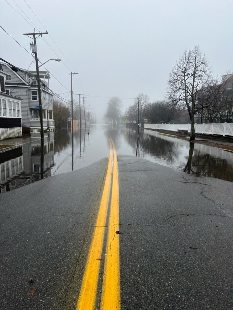 a wet road with a yellow line (MyCoast AI)