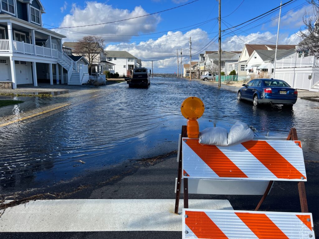 a flooded street with a boat and cars (MyCoast AI)