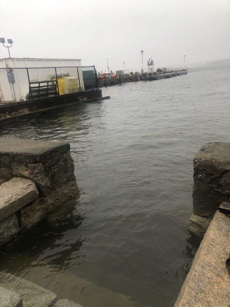a body of water with a dock and a building on the side (MyCoast AI)