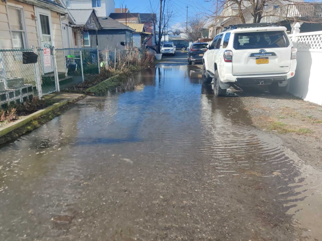 a flooded street with cars and houses (MyCoast AI)