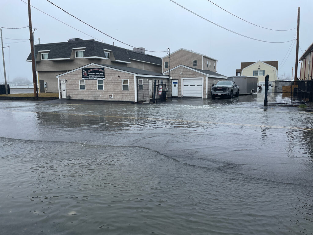a flooded street with a car driving through it (MyCoast AI)