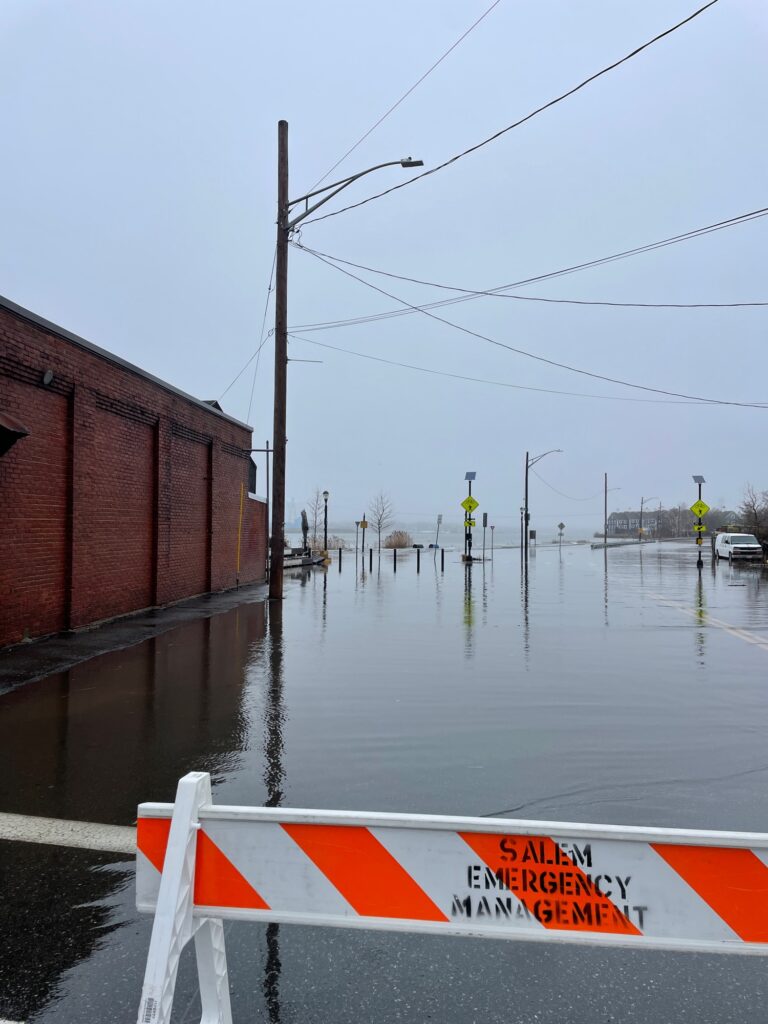 a flooded street with a red and white sign (MyCoast AI)