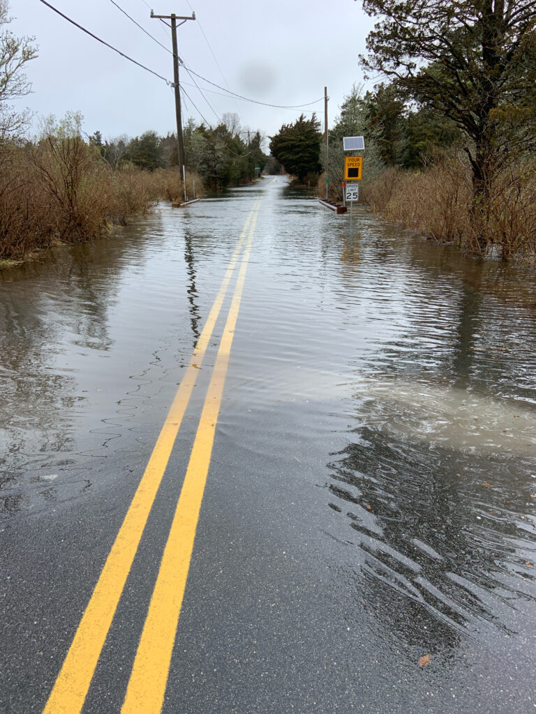 a flooded road with a yellow sign (MyCoast AI)