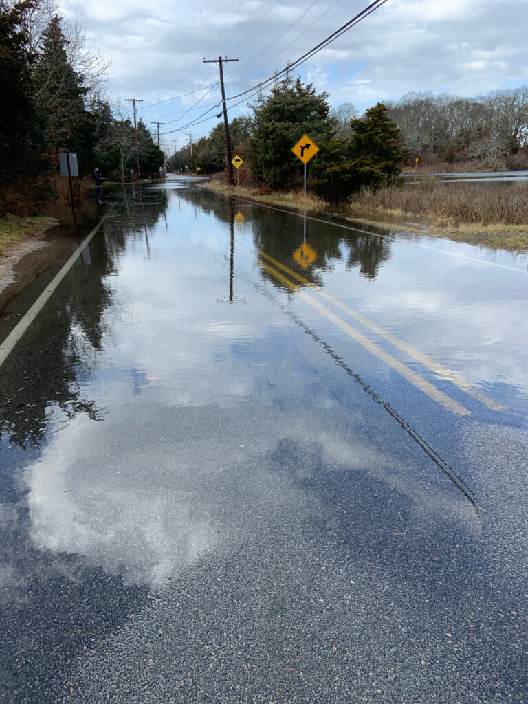 a flooded road with a yellow sign (MyCoast AI)