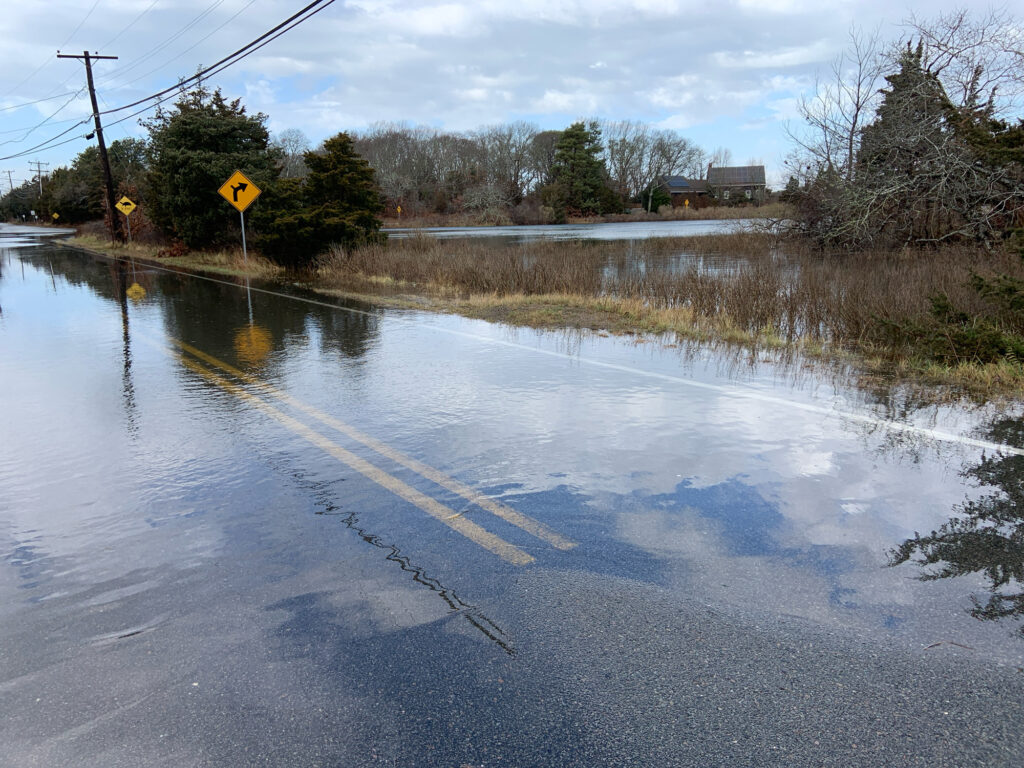 a flooded road with a yellow sign (MyCoast AI)
