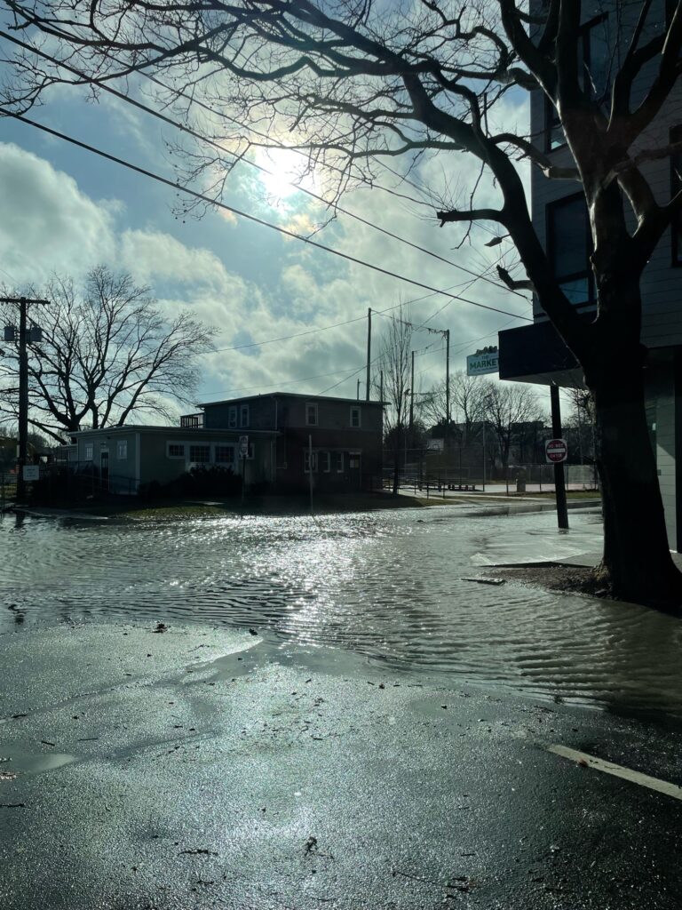 a wet street with buildings on either side of it (MyCoast AI)