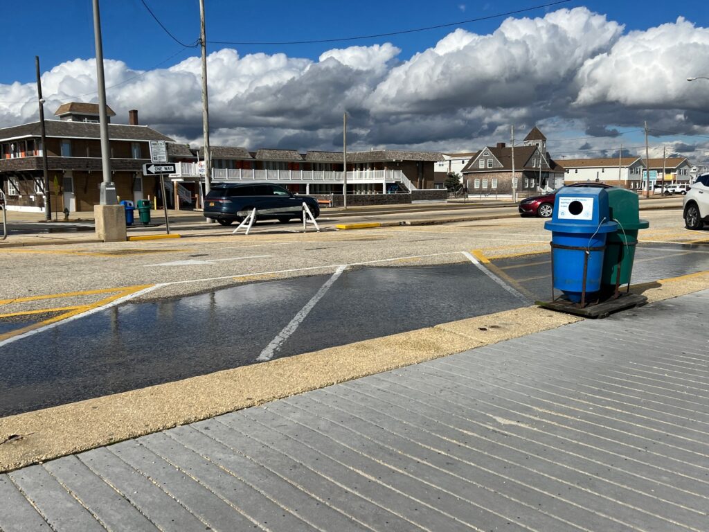 a parking lot with a blue trash can and a blue trash can (MyCoast AI)