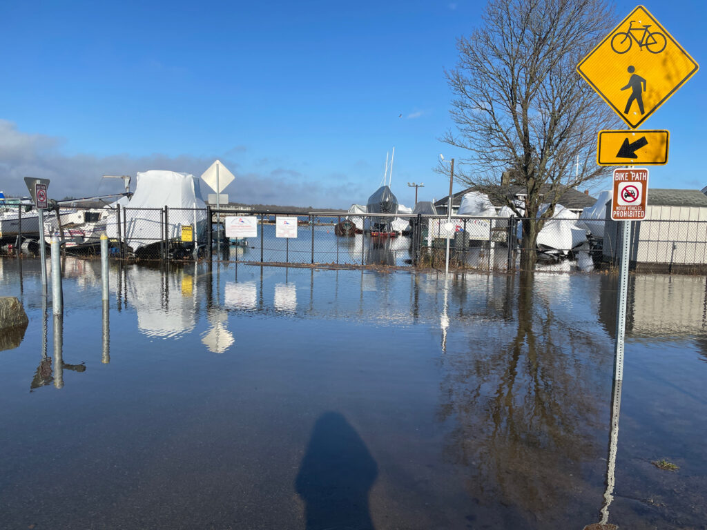 a flooded street with a yellow sign (MyCoast AI)