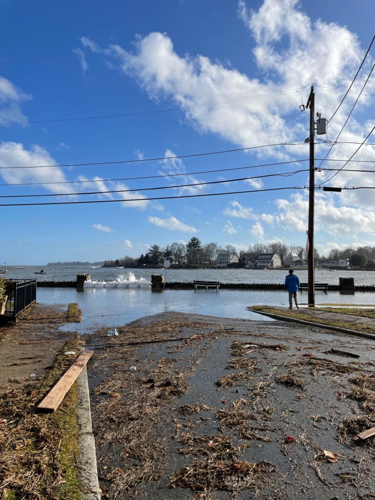 a man standing on a sidewalk next to a body of water (MyCoast AI)