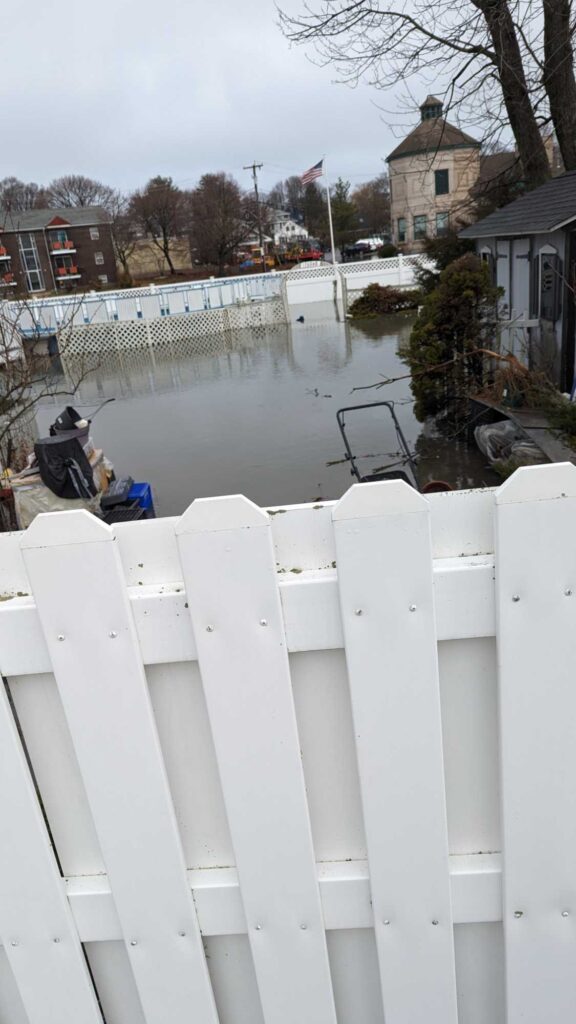 a white fence with a white railing and a body of water in the background (MyCoast AI)