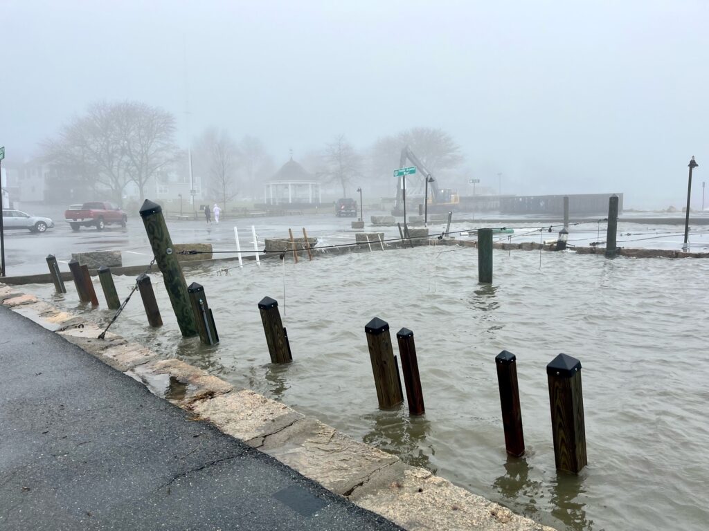a body of water with a dock and a walkway with a building in the distance (MyCoast AI)