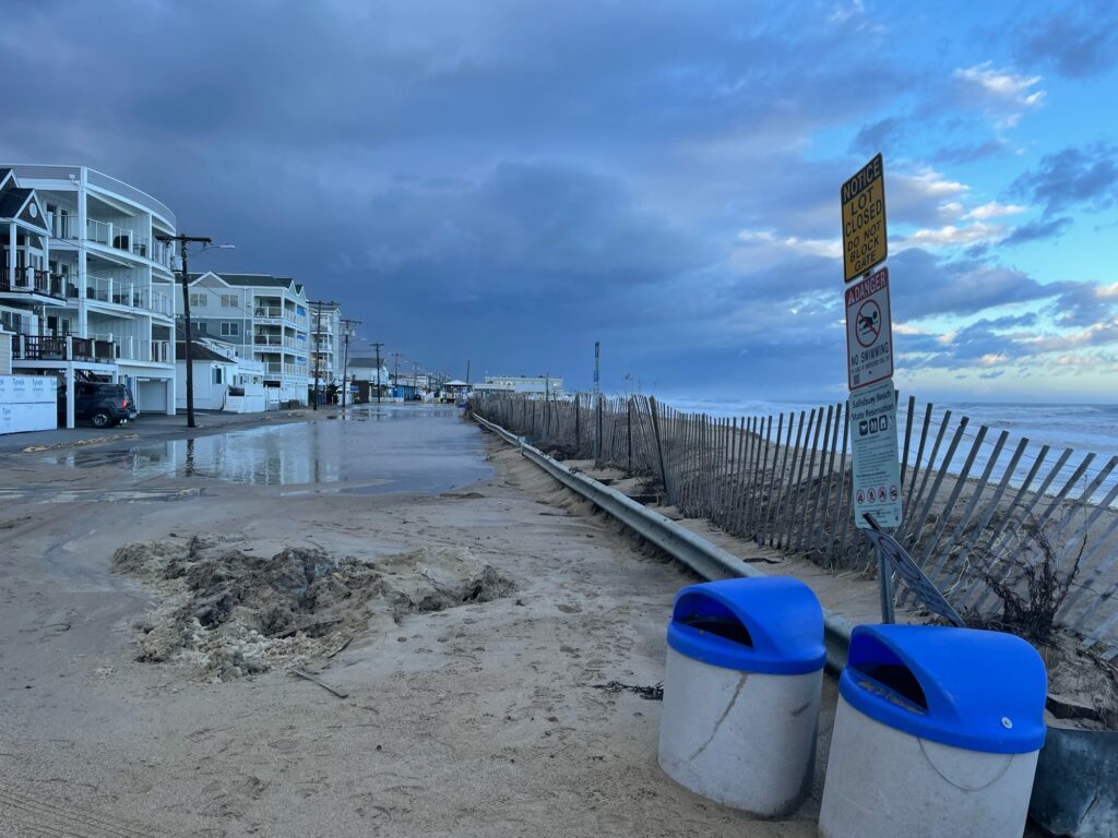 a beach with a sign and trash cans (MyCoast AI)