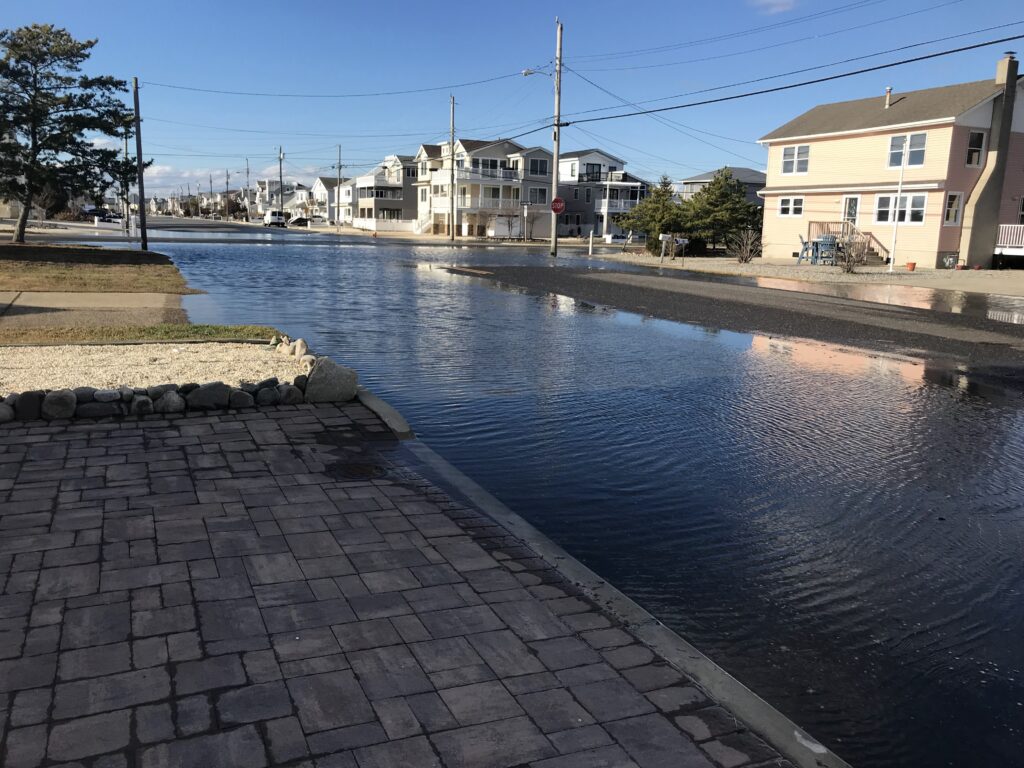 a brick walkway next to a body of water with buildings in the background (MyCoast AI)