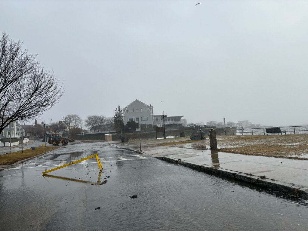a road with a puddle and buildings on the side (MyCoast AI)