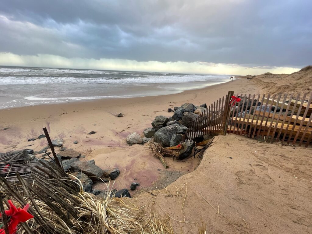 a beach with a fence and a pile of wood on it (MyCoast AI)