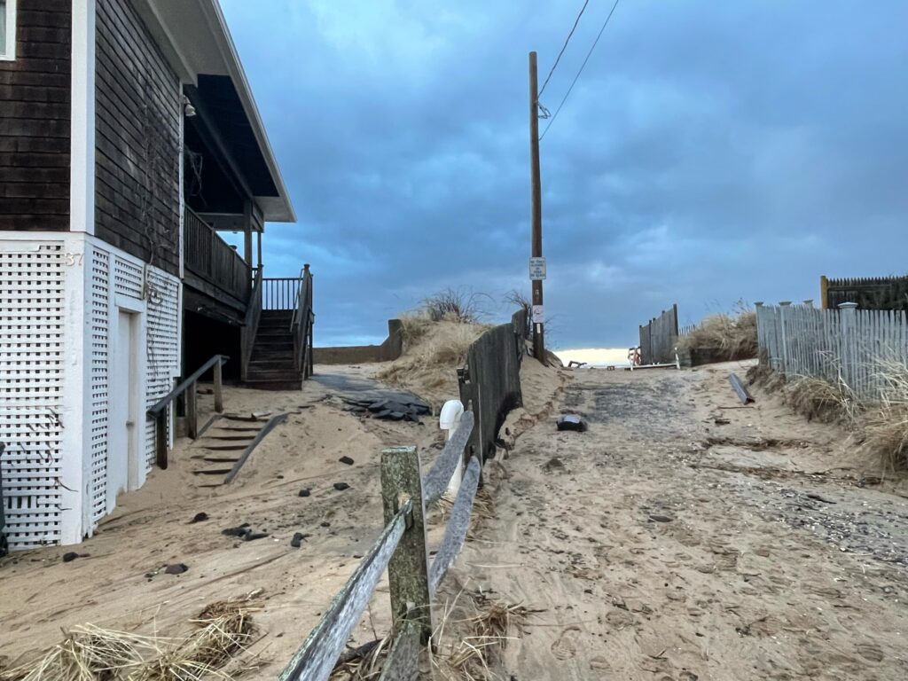 a dirt road with a fence and a building on the side (MyCoast AI)